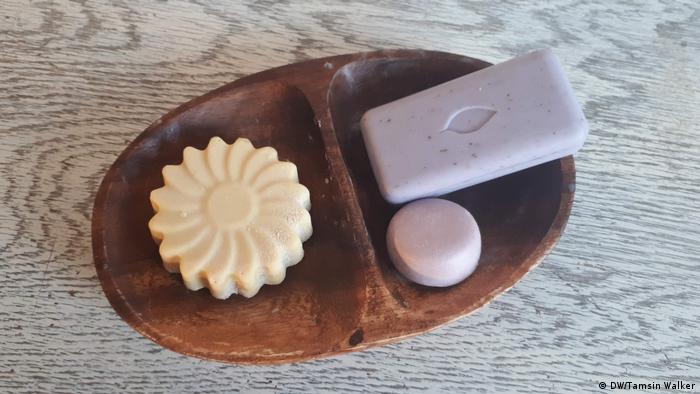 A wooden dish containing three bars of soap