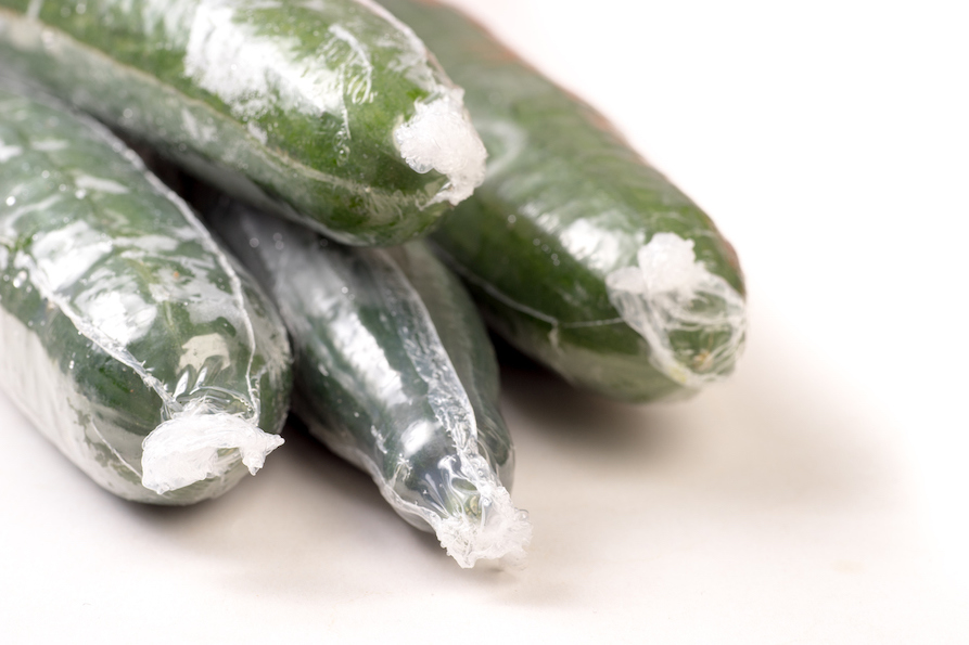 Bunch of cucumber wrapped in plastic films, isolated on white background