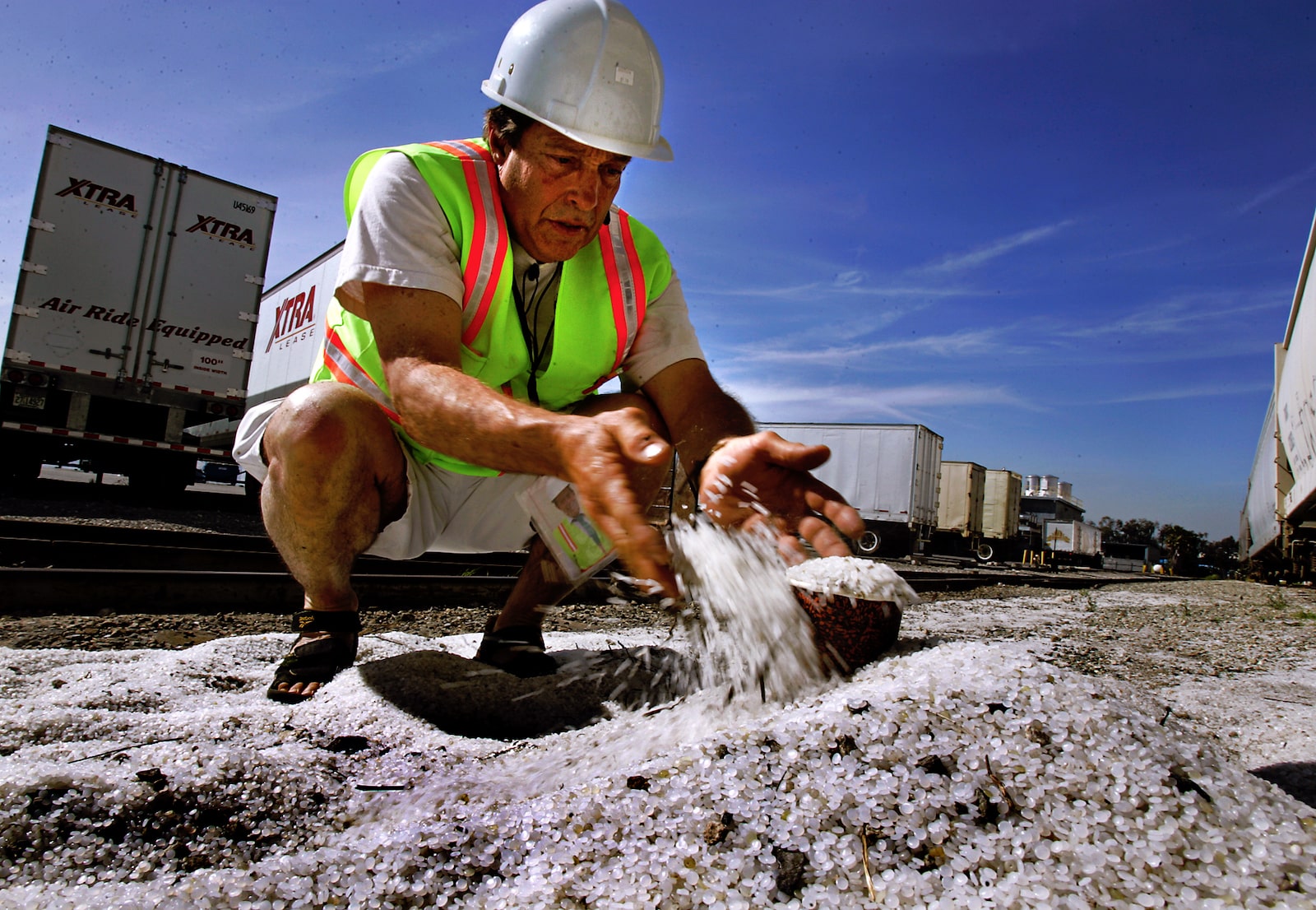 Charles Moore holds up nurdles on the floor outside of a production plant in Vernon, CA.