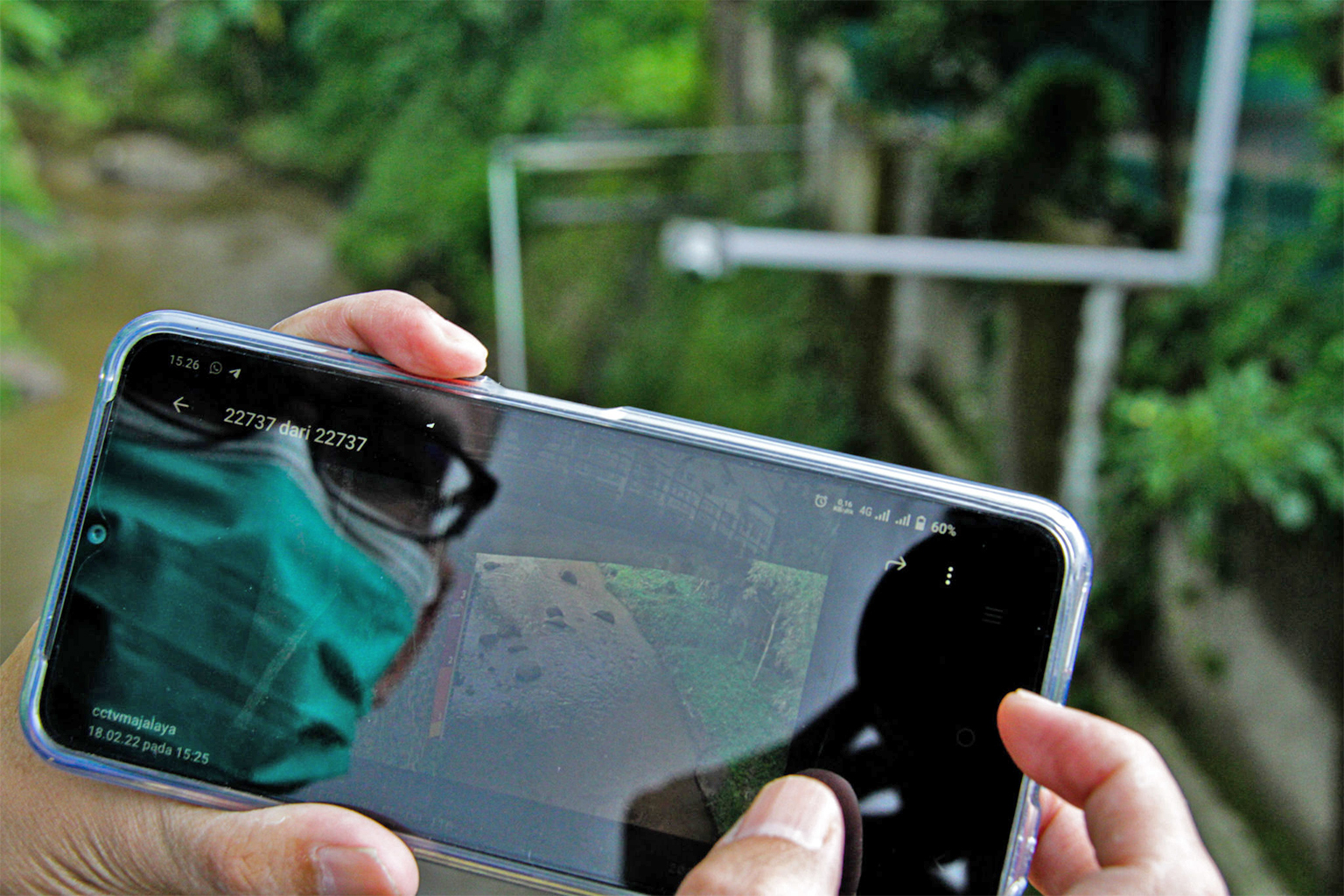 Riki Waskito uses his phone to monitor water levels