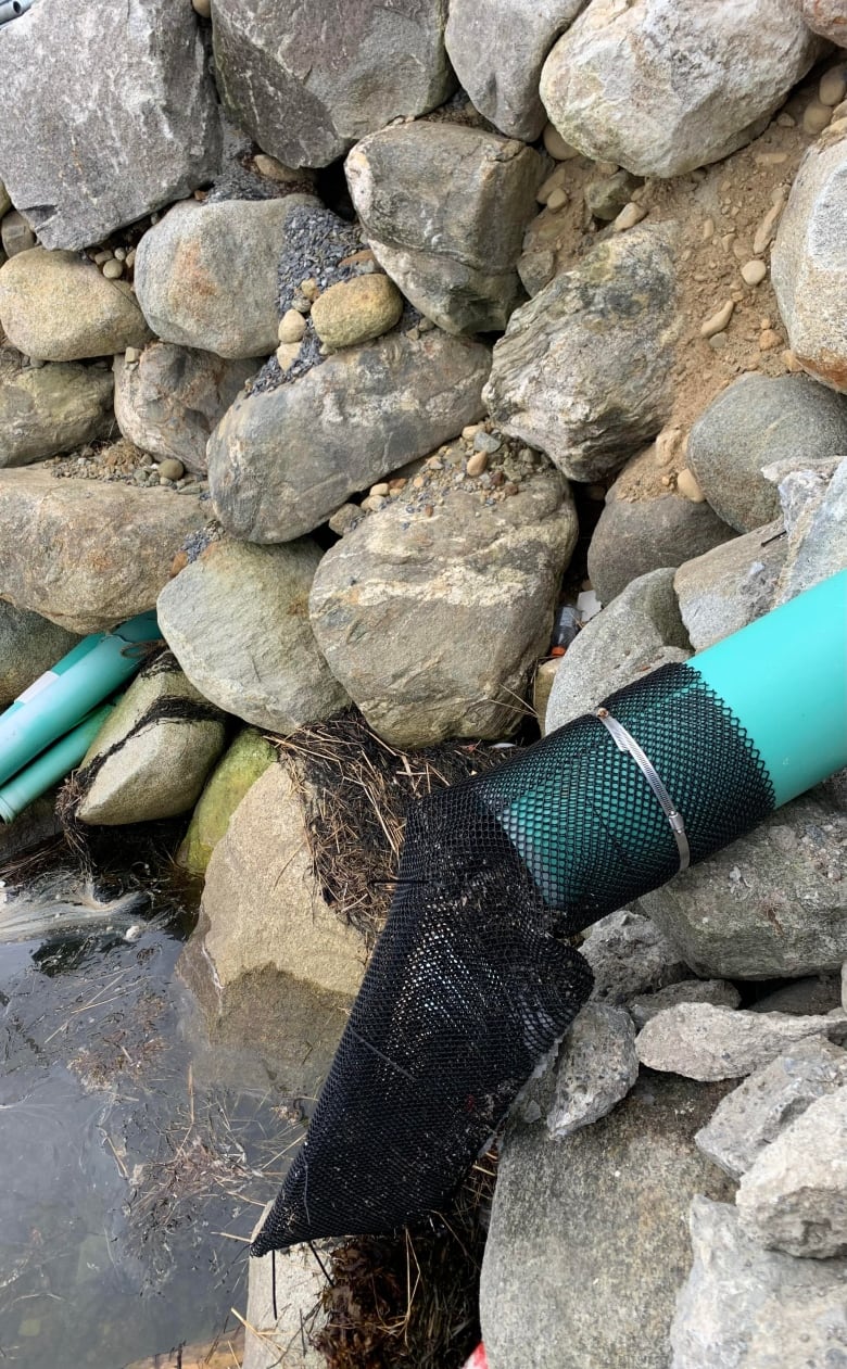 A mesh sock is shown on a discharge pipe