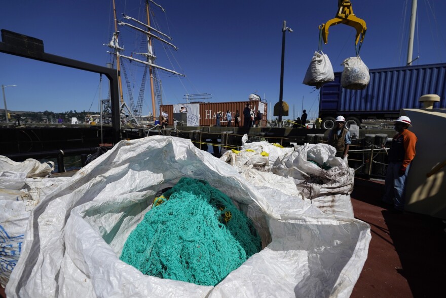 Bags filled with plastics and debris from the North Pacific Gyre are unloaded from the Ocean Voyages Institute sailing cargo ship Kwai in Sausalito, Calif., Wednesday, July 27, 2022. The ship returned with plastics from the ocean after 45 days in the area more commonly known as the "Great Pacific Garbage Patch." The plastics are to be recycled, upcycled and repurposed.