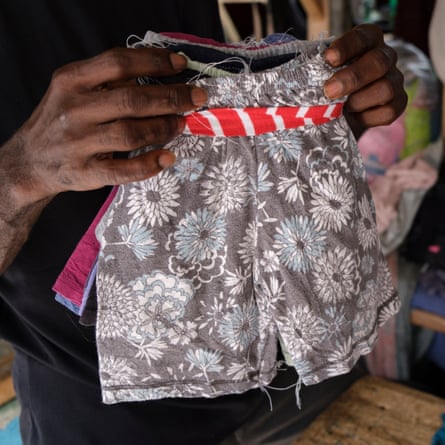 An upcycler with a pair of shorts made from secondhand clothes at Kantamanto market in Accra, Ghana
